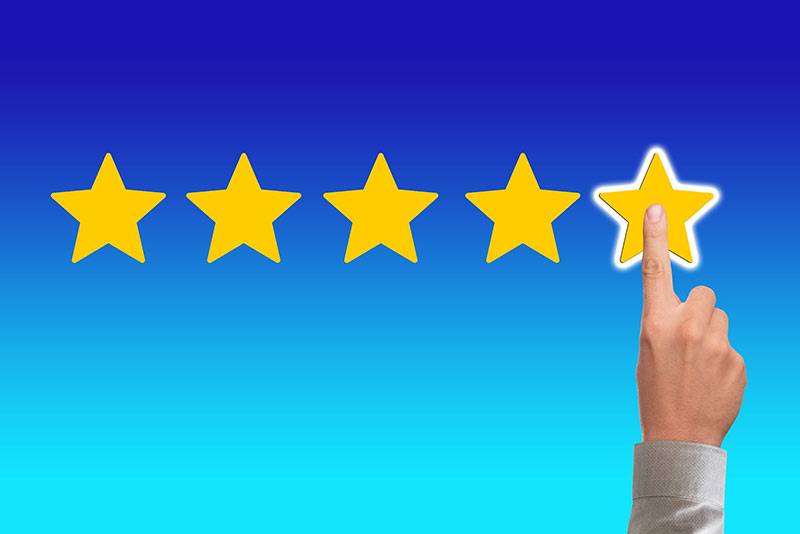 A hand selecting 5 stars, illustrating the need to respond to reviews online with a reputation management plan